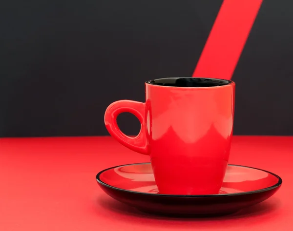 Rode koffiekopje op een zwarte achtergrond — Stockfoto