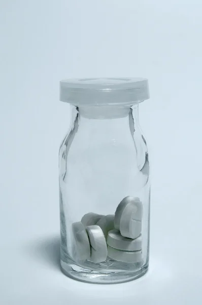 Tabletki w szklanym pojemniku — Zdjęcie stockowe