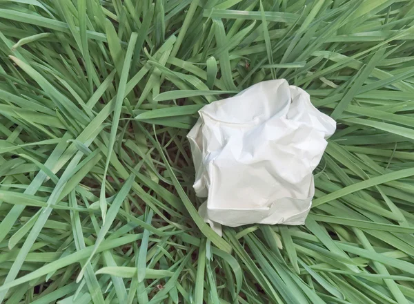 Papier gedumpt op gras — Stockfoto