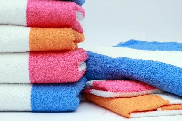Ręczniki frotte kolor połączone przez stos na białym tle. na białym tle. — Zdjęcie stockowe
