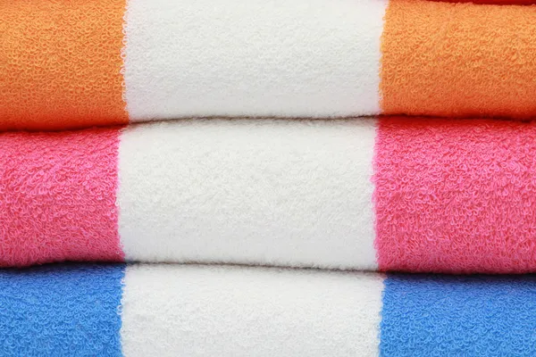 Serviettes éponge de couleur combinées par pile sur fond blanc. Isolé . — Photo