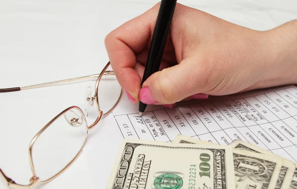 Женская рука с ручкой и бумагой и долларом — стоковое фото
