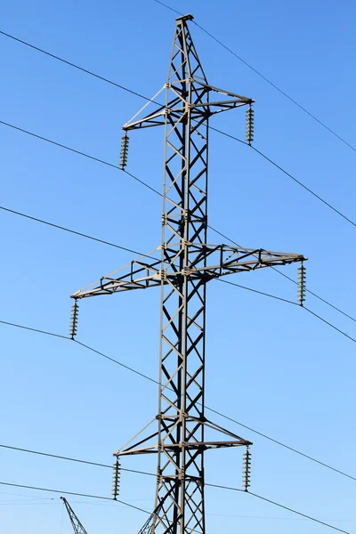 Široký úhel pohledu pylonu elektřiny proti modré oblohy jasno — Stock fotografie
