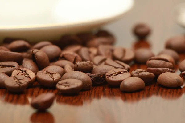 Taza de café y grano sobre fondo blanco —  Fotos de Stock