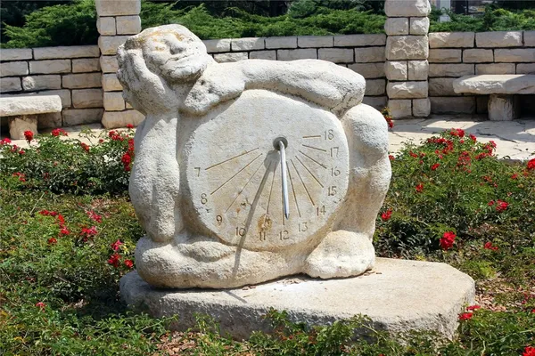 Escultura del reloj de sol en el jardín de rosas — Foto de Stock