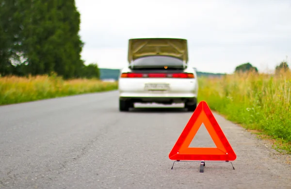 stock image Red warning triangle with a broken down car