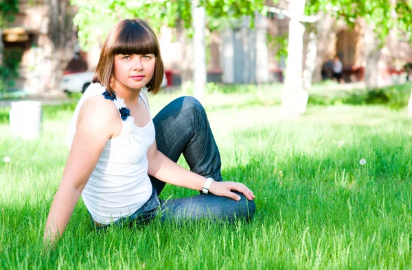 잔디 위에 앉아 있는 소녀 — 스톡 사진