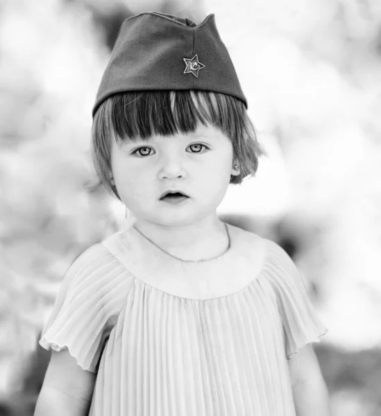 Foto in bianco e nero di una ragazza carina con i berretti di un soldato — Foto Stock