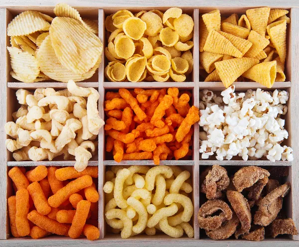 Variety of crunchy snacks in a box — Stock Photo, Image