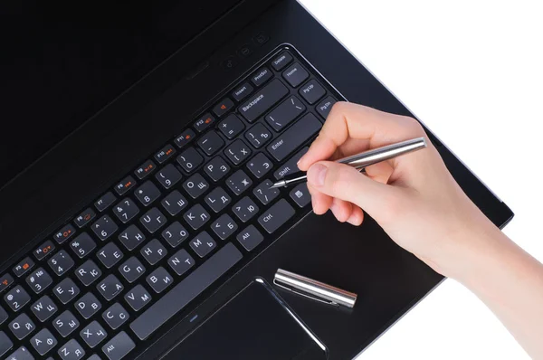 Mão com caneta no teclado do laptop — Fotografia de Stock