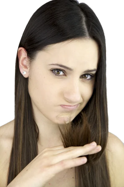 Depressed girl makes funny face showing destroyed long hair — Stock Photo, Image