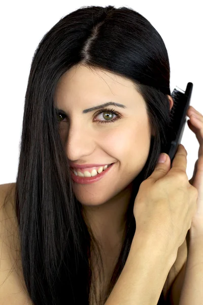 Närbild av kvinnlig modell borsta hennes långa hår — Stockfoto