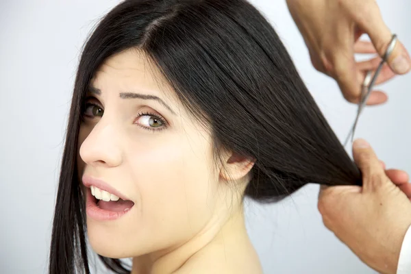 Красива жінка кричить, поки її довге волосся порізане — стокове фото
