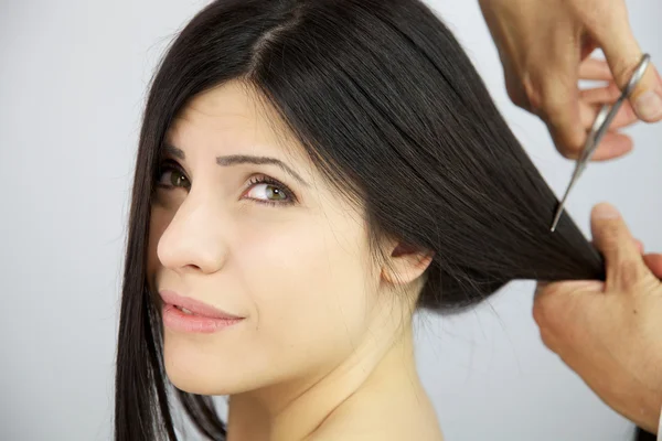 Жінка турбується про те, що її довге волосся нарізають — стокове фото