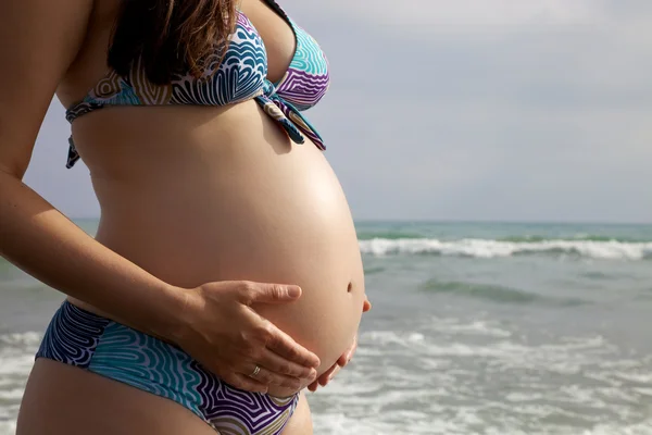 Piękny brzuch w ciąży nad brzegiem morza — Zdjęcie stockowe