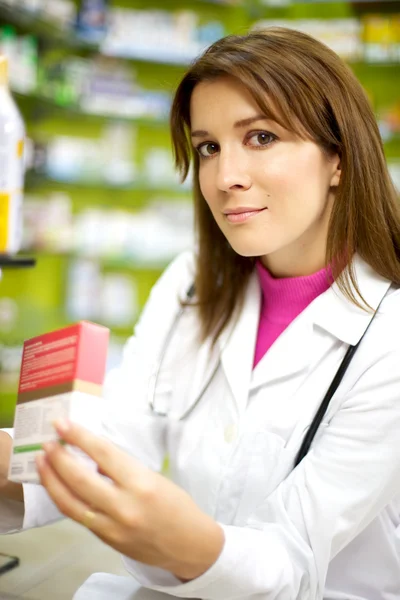 Young female doctor in pharmacy smiling — Stock Photo, Image