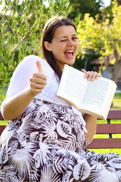 Mujer embarazada feliz con el pulgar del libro hacia arriba — Foto de Stock
