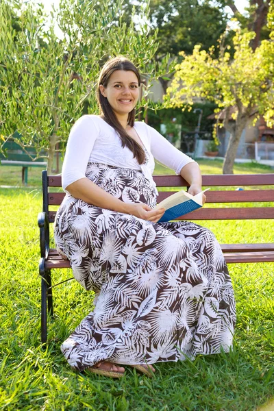 Felice donna incinta lettura libro in bel giardino — Foto Stock