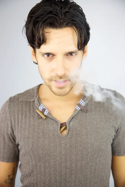 Handsome man with smoke coming out of his mouth — Stock Photo, Image