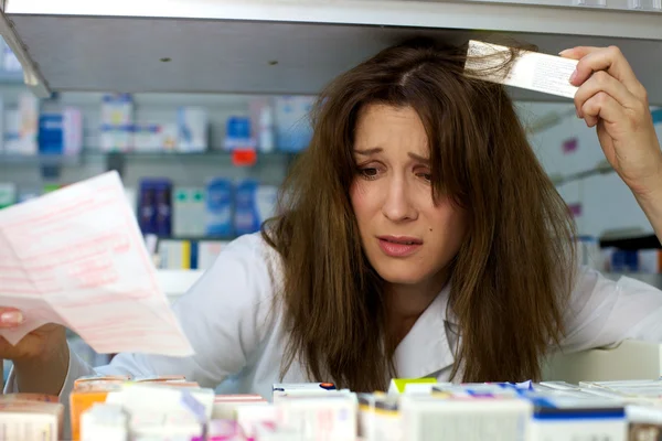 Kétségbeesett gyógyszerész nő nem megtalálás a gyógyszer — Stock Fotó