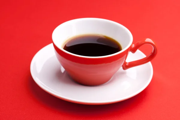 Šálek horké kávy na červeném pozadí — Stock fotografie
