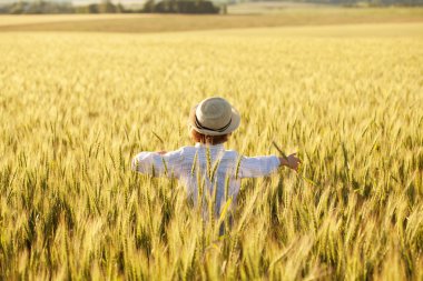 Joyful little boy running around in a field clipart