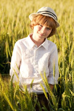 Boy wearing a hat stands clipart