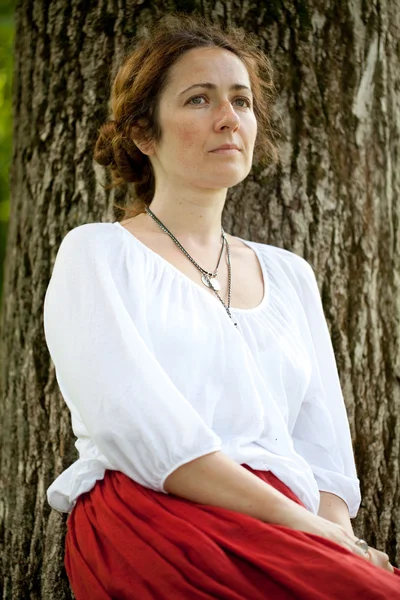 Ung kvinna i vit blus sammanträde — Stockfoto