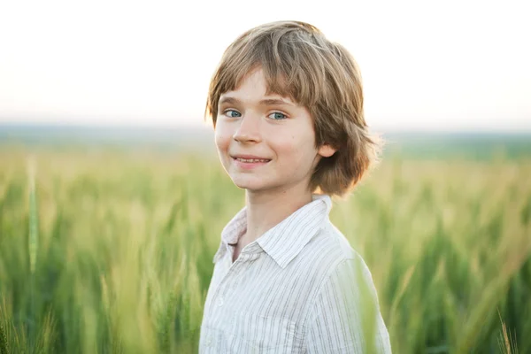 Fröhlicher Junge gegen ein Weizenfeld — Stockfoto