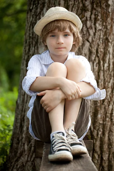 Chłopiec w kapeluszu na ławce — Zdjęcie stockowe