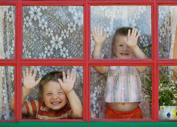 Twee kinderen rond gek en tonen de gezichten — Stockfoto