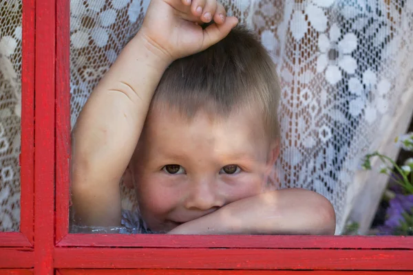 Kid está situado perto da janela — Fotografia de Stock
