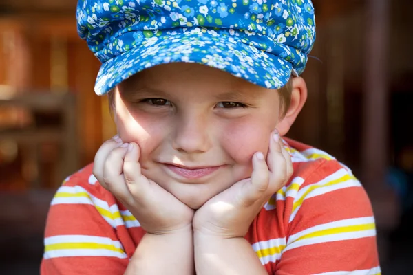 Boy in the blue cap sits — Stock Photo, Image
