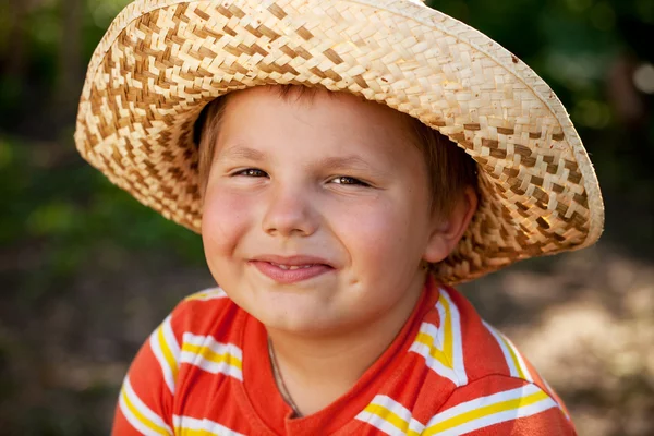 Uśmiechnięty chłopiec w kapeluszu wiklinowe — Zdjęcie stockowe