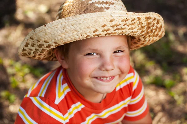 Ευτυχισμένο αγόρι σε ένα ψάθινο καπέλο — Φωτογραφία Αρχείου