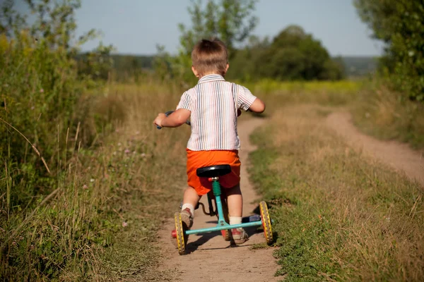 Kleine jongen rijdt een driewieler — Stockfoto