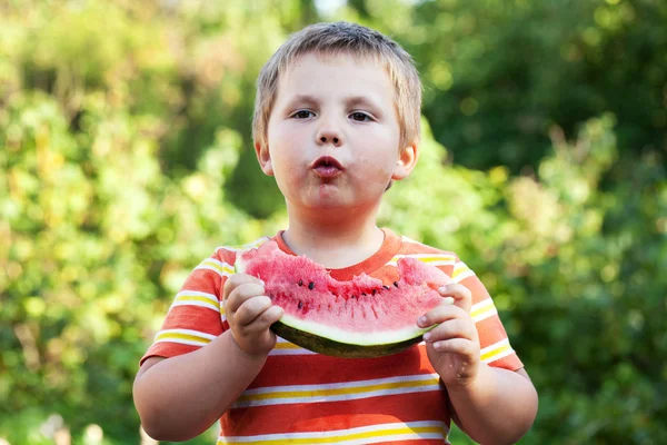 Menino com apetite por comer melancia madura — Fotografia de Stock