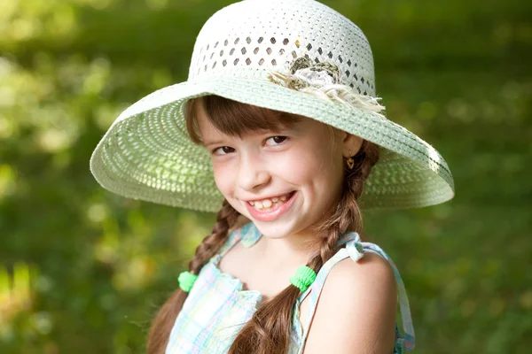 Glad flicka med flätor i hatten — Stockfoto