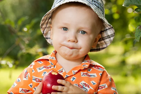 Charming babe in panama eating delicious apple — Stock Photo, Image