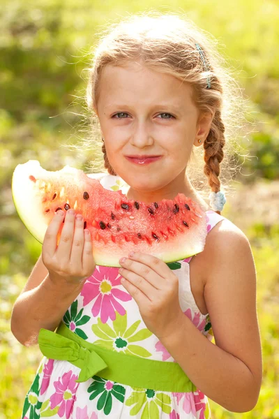 Blonde girl with pigtails eating a watermelon — Stock Photo, Image