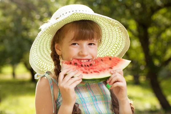 Dívka v klobouku jíst meloun červený — Stock fotografie