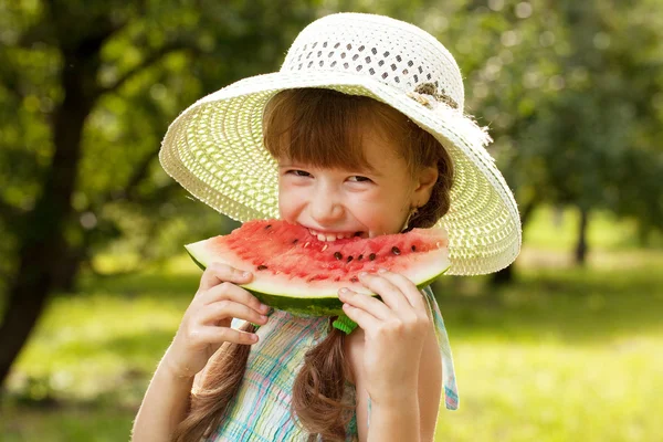 Menina no chapéu e vestido comendo uma melancia — Fotografia de Stock