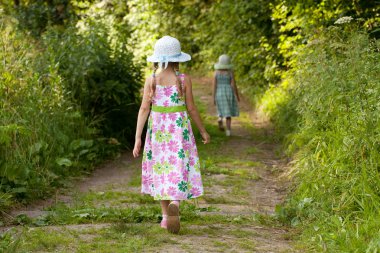 Two girls are on the trail in the forest clipart