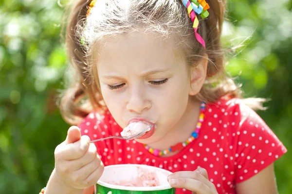 Menina em uma blusa vermelha com sabor comer sorvete — Fotografia de Stock