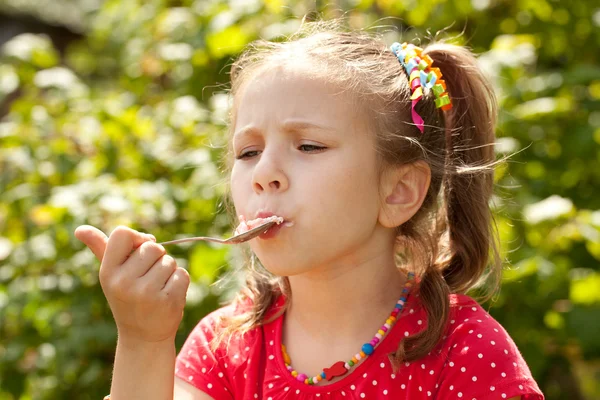 アイスクリームを食べる赤いブラウスの少女 — ストック写真