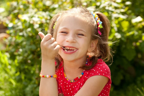 Menina engraçada em uma blusa vermelha comendo sorvete — Fotografia de Stock
