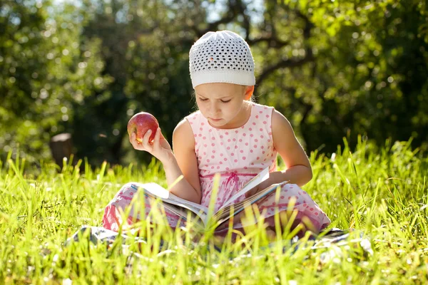 漂亮的女孩正在读一本儿童读物 — 图库照片