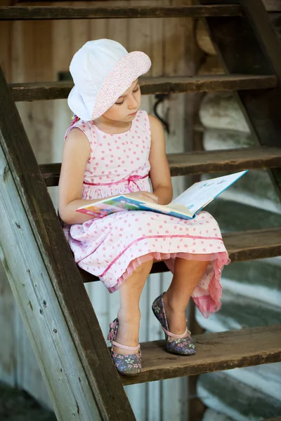 漂亮的女孩正在读一本儿童读物 — 图库照片