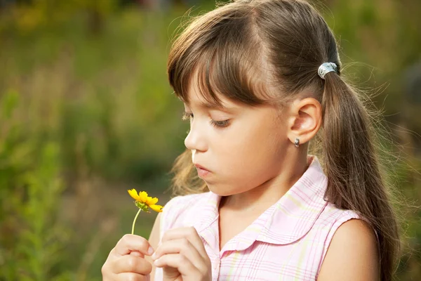 Petite fille mignonne jouant avec une fleur — Photo