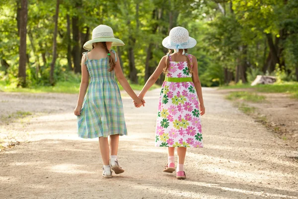 Two girls go hand in hand — Stockfoto